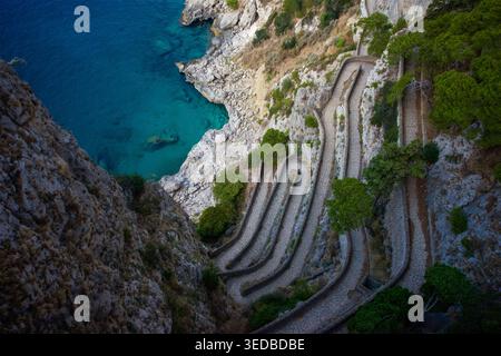 Vue aérienne du chemin de pierre sinueux de la via Krupp creusé dans des falaises abruptes surplombant la mer Tyrrhénienne turquoise à Capri, Campanie, Italie. Banque D'Images