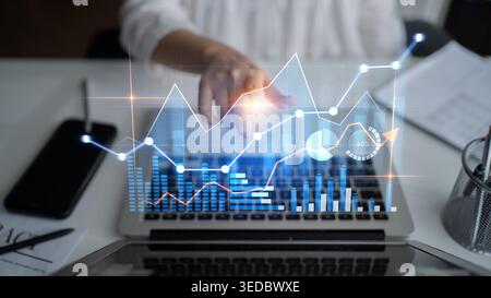 Professionnel s'engage avec l'analyse numérique et la visualisation de données sur un ordinateur portable dans un bureau moderne, mettant en valeur la technologie pour informé Banque D'Images