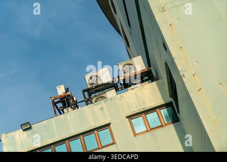 Des climatiseurs sont installés sur le toit d'un bâtiment. Cette image présente la technologie de refroidissement moderne sur fond de ciel bleu, highlig Banque D'Images