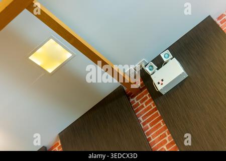 Une vue saisissante mettant en valeur un design intérieur moderne, avec des plafonniers, des poutres en bois et des murs texturés, améliorant l'ambiance générale de la s. Banque D'Images