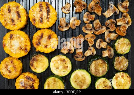 Cuisson du maïs, de la courgette et des champignons ensemble sur la plaque Home Grill Banque D'Images
