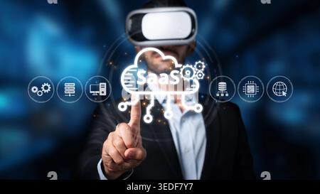 Un homme d'affaires porte un casque de réalité virtuelle tout en interagissant avec les icônes de la technologie cloud qui signifient le logiciel en tant que service dans un contemporain Banque D'Images