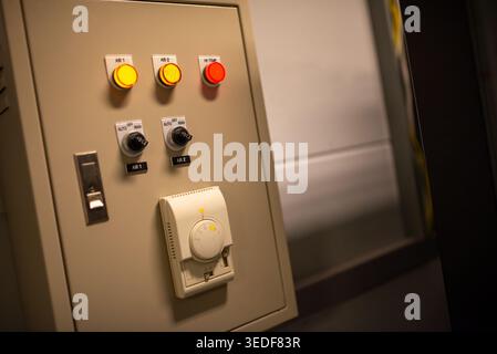 Vue rapprochée d'un panneau de commande avec divers interrupteurs et boutons utilisés pour le fonctionnement des machines et les réglages électriques dans un environnement industriel Banque D'Images