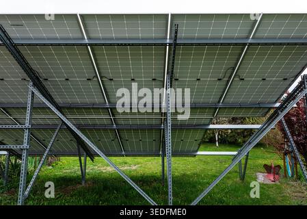 Panneaux photovoltaïques générant de l’électricité propre installés sur des racks métalliques dans un jardin Banque D'Images