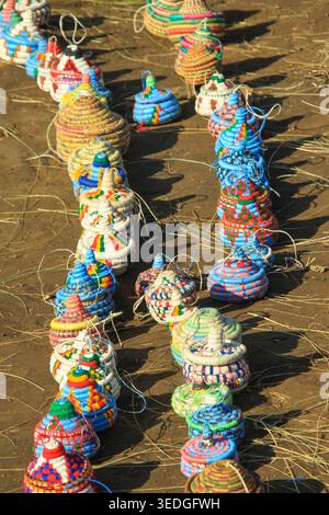 Artisan a fait des paniers colorés avec des motifs tissés complexes et des motifs traditionnels, disposés sur le sol sous la lumière naturelle, représentant loc Banque D'Images