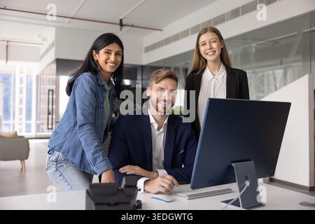 Groupe de trois professionnels posant pour caméra dans un bureau moderne Banque D'Images