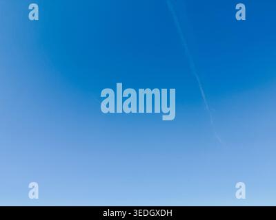 Fond de ciel bleu propre avec des traînées d'avion subtiles créant une composition minimaliste. Idéal pour l'aviation, le voyage, la liberté ou les concepts d'entreprise w Banque D'Images