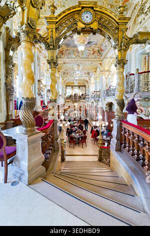 Les gens apprécient les boissons et la conversation au New York Cafe, un endroit célèbre de Budapest. Le décor élégant ajoute du charme à l'expérience. Banque D'Images