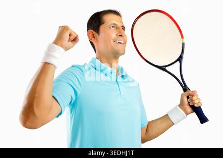 Portrait d'un jeune joueur de tennis masculin célébrant une victoire isolé sur fond blanc Banque D'Images
