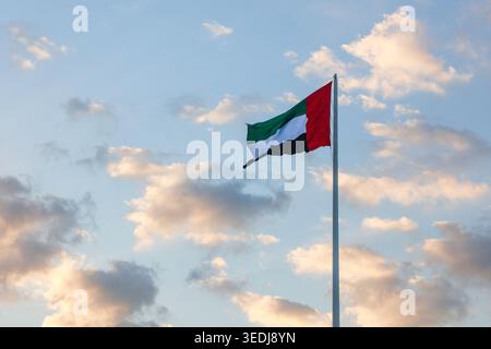 Le drapeau national des Émirats arabes Unis vole, dans la brise, au-dessus de la corniche de Qawasim, Ras Al Khaimah, Émirats arabes Unis Banque D'Images