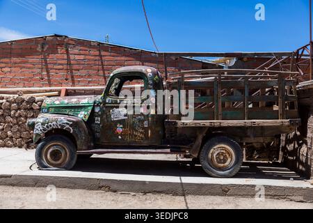 Un camion vintage lourdement altéré, couvert d'autocollants, de graffitis et de décennies de rouille, est stationné le long d'une rue à Uyuni, en Bolivie. Le véh Banque D'Images