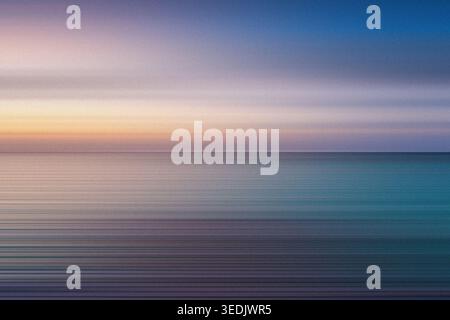 Un magnifique paysage marin abstrait avec des dégradés de couleurs doux et horizontaux passant des teintes chaudes du coucher de soleil aux tons bleus froids, créant un m tranquille Banque D'Images