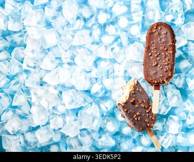 Crème brulee crème glacée popsicles recouvertes de chocolat au lait et de noix sur glace. Vue de dessus. Banque D'Images