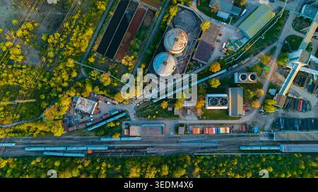 Vue aérienne des objets d'infrastructure Malesice avec silos industriels, voies ferrées avec trains bleus et arbres verdoyants à Hlavni mesto Praha Banque D'Images