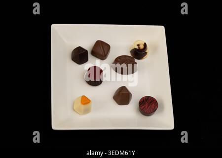 Assortiment de chocolats artisanaux Gourmet sur une assiette carrée blanche Banque D'Images
