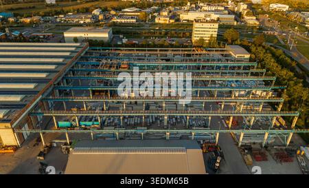Vue aérienne des objets d'infrastructure de Malesice avec des entrepôts industriels, des parcs de stockage extérieurs et des ponts roulants sous la lumière de l'heure d'or à Hlavn Banque D'Images