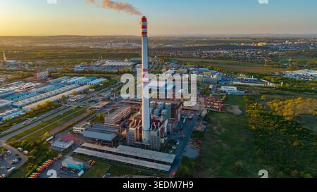 Vue aérienne des objets d'infrastructure Malesice avec une grande cheminée industrielle avec des rayures rouges et de la fumée pendant le coucher du soleil à Prague, Hlavni mest Banque D'Images