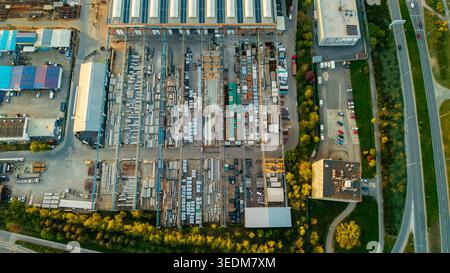 Vue aérienne des objets d'infrastructure de Malesice avec entrepôts industriels, dépôts extérieurs avec matériaux de construction et portiques HLA Banque D'Images