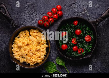 Omelette cuite et épinards avec tomates dans des casseroles, vue de dessus. Banque D'Images