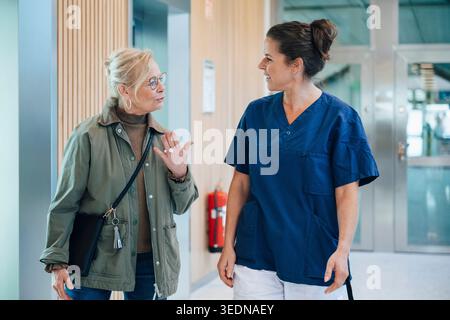 Femme âgée discutant avec une infirmière après sa visite à l'hôpital Banque D'Images