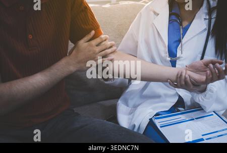 Travailleur de la santé fournissant un soutien empathique et des soins, en plaçant doucement les mains sur le bras d'une femme âgée Banque D'Images