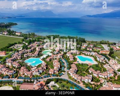 Vue aérienne du lac de Garde avec des bâtiments de luxe avec piscines turquoise et paysages verdoyants Italie. Banque D'Images