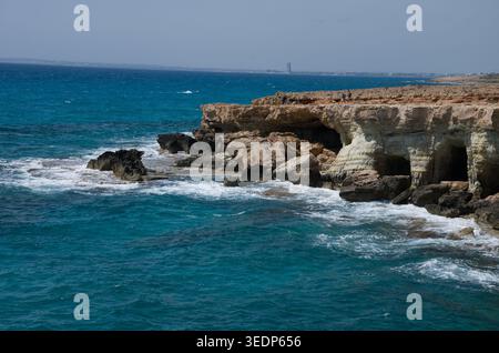 Falaises côtières rocheuses avec grottes et mer turquoise Banque D'Images