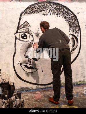 Un artiste graffiti peint dans le tunnel de Leake Street Banque D'Images