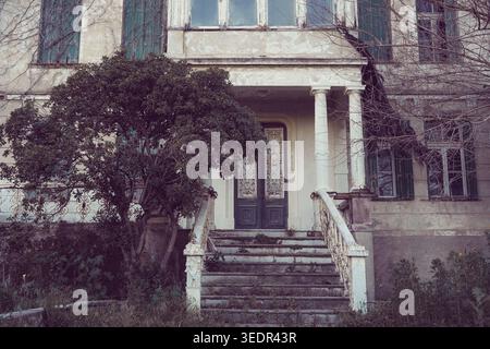 Porte d'entrée ornée avec colonnes ioniques et escalier en ruine du manoir néoclassique abandonné à Mytilene, Lesbos, Grèce Banque D'Images