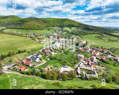 Vue aérienne de la forêt luxuriante gren et des champs étendus avec le village Podzamcok en Slovaquie Banque D'Images