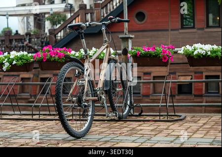 Un vélo se tient à côté des jardinières à Skopje avec des couleurs vives par une belle journée Banque D'Images