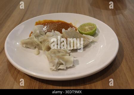 Siomay, boulettes de poisson indonésiennes à la sauce aux arachides servies sur une assiette blanche Banque D'Images