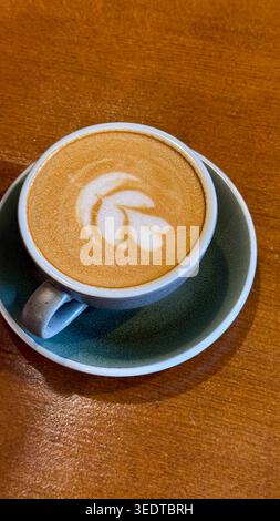 Cappuccino frais servi dans un café, avec une mousse crémeuse et une présentation minimaliste pour un concept de café et de style de vie cosy. Banque D'Images