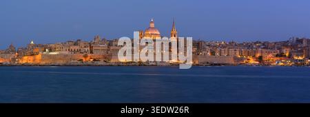 Vue panoramique de Valletta Skyline au crépuscule vu du port de Sliema avec des lumières sur la cathédrale de Pauls, Malte. Banque D'Images