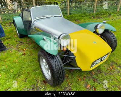 Voiture de sport britannique classique Lotus Seven avec carrosserie verte et jaune emblématique garée sur un terrain herbeux Banque D'Images