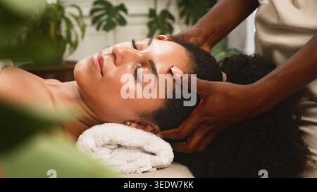Massage relaxant de la tête dans Un spa avec femme recevant un traitement du cuir chevelu et une relaxation du visage Banque D'Images