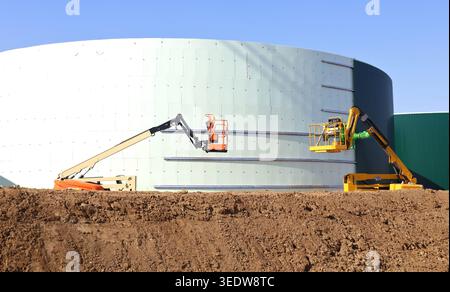 Deux cueilleurs Cherry travaillent à la construction d'un grand réservoir industriel dans l'industrie pétrolière Banque D'Images