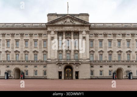 La grande façade du palais de Buckingham à Londres avec les gardes royaux debout à leurs postes Banque D'Images