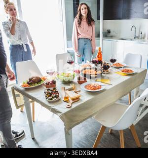 Amis et famille réunis autour d'une table en dégustant un dîner maison Banque D'Images