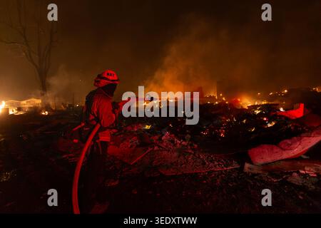 Un pompier utilise un tuyau d'eau pour combattre l'incendie de Dixie à Greenville, EN CALIFORNIE, le 4 août 2021. Banque D'Images