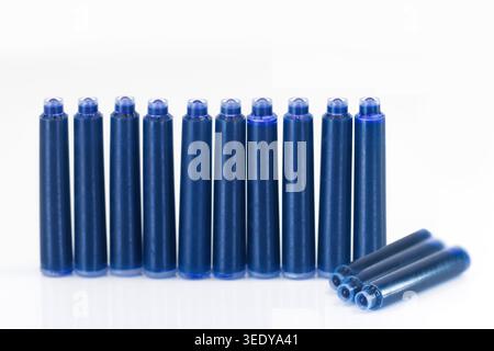 Rangée de cartouches d'encre de stylo plume bleu sur fond blanc, plan de studio en gros plan symbolisant l'écriture, l'école, les fournitures de bureau et la recharge Banque D'Images