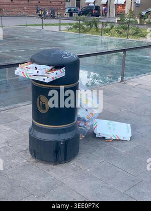 Cremona, Italie 9 avril 2026 débordement de poubelle publique avec des boîtes à pizza et des sacs en plastique de déchets symbolisant les déchets urbains et la conc. Environnementale Banque D'Images
