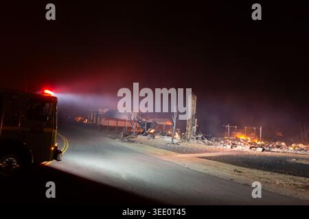 Un camion de pompiers chaud brille sa lumière sur des structures en feu à Greenville, CA le 4 août 2021 alors que le feu de Dixie brûle à travers la ville. Banque D'Images