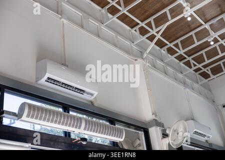 Mur intérieur blanc moderne avec climatiseur monté pour un refroidissement confortable sous une structure de plafond industrielle créant un rafraîchissement calme Banque D'Images
