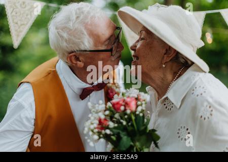 Couple senior embrassant pendant la cérémonie de mariage. Banque D'Images