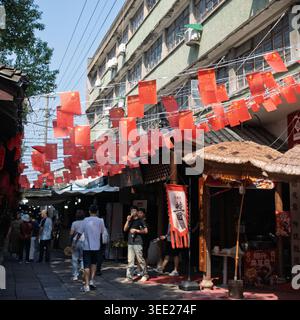 Drapeaux nationaux chinois vibrants décorant une rue piétonne traditionnelle animée à Hangzhou, en Chine Banque D'Images