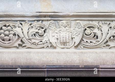 Gros plan de frise en pierre avec motif hibou et motif de volutes ornées sculpté dans la façade du bâtiment Victoria College. Banque D'Images