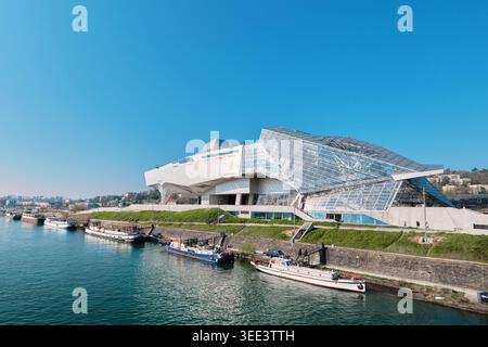 Lyon, France - 19 mars 2026 : vue panoramique de l'architecture déconstructiviste du Musée des Confluences au bord du Rhône avec des bateaux au premier plan Banque D'Images