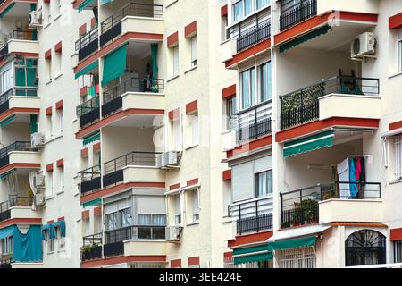 Immeuble résidentiel avec balcons, auvents verts et détails domestiques quotidiens tels que des unités de blanchisserie et de climatisation. Banque D'Images