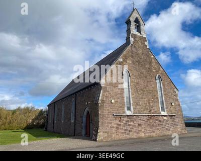 Une petite église de campagne historique faite de pierre de carrière altérée avec un front de pignon caractéristique et un clocher étroit. Banque D'Images